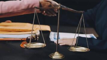 Two people shaking hands over a scale of justice video
