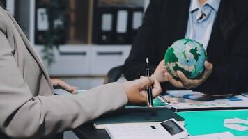 Business people working on a project with a globe video