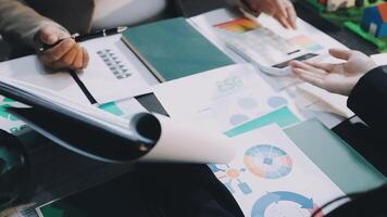 Business people working on a table with papers and calculators video