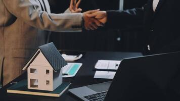 Two people shaking hands over a model house video