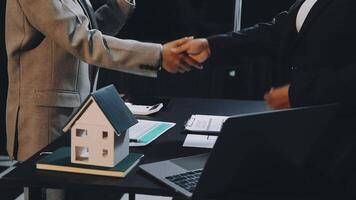Two people shaking hands over a house model video