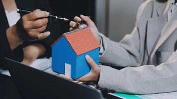 A man and woman are holding a house model video