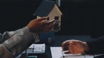 Two people holding a house model over a table video