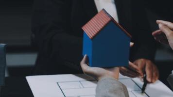 Two people holding a house model on a table video