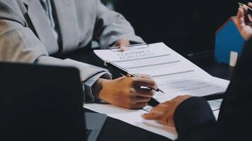 A businessperson signing a contract with another person video
