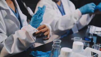 Two people in lab coats and gloves working on something video