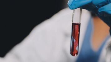 A person in a lab coat holding a blood sample video