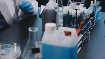 A person in a lab coat is working on a test tube video