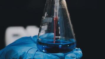 A person holding a test tube with a liquid inside video
