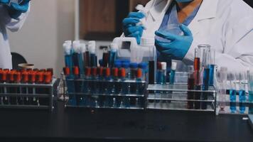 dois pessoas dentro laboratório casacos e luvas trabalhando em uma mesa video