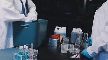Two people in lab coats are working on a table video