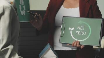 A woman holding a net zero sign in front of a house video