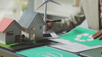 A woman is working on a house with a wind turbine on the table video