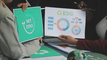 Two people holding up papers with the words net zero on them video