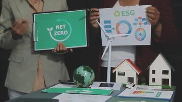 Two people holding up a sign that says net zero video