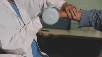 A doctor is helping a patient with a dumbbell video