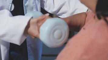 A doctor is holding a dumbbell in front of a woman video