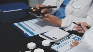 Two doctors are working on a computer and a tablet video