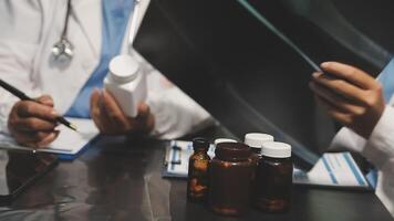 Two doctors are working on a laptop and a tablet video