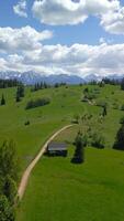 Hiking trail among idyllic green pastures with peaks of Tatra mountains Aerial video