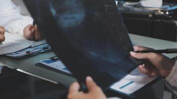 A group of people sitting at a table with a piece of paper video