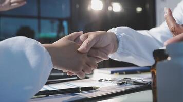 Two doctors shaking hands over a desk video