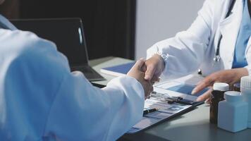 Two doctors shaking hands at a desk video
