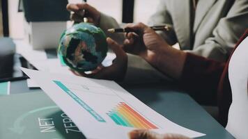 Business people working on a paper with a globe video