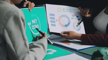 Two people are looking at a paper with the words net zero on it video