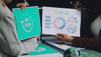 Two people holding up papers with the words net zero on them video