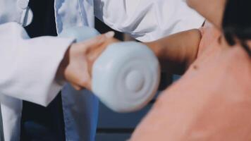 A doctor is holding a dumbbell in front of a woman video