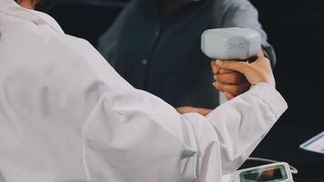 A person holding a white device in front of a computer video