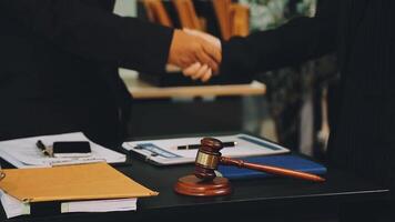 Two lawyers shaking hands over a table with a gavel video