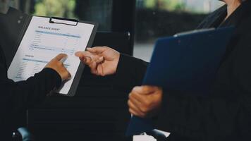 Two business people are holding a clipboard and looking at a document video
