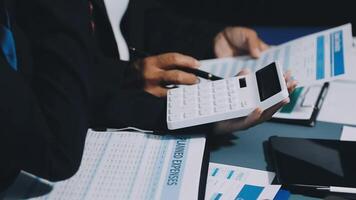 Business people working on paperwork and using a calculator video