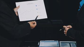 Two business people are holding a piece of paper with graphs on it video