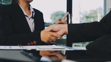 Two business people shaking hands at a table video