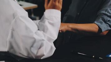 Two people shaking hands at a table video