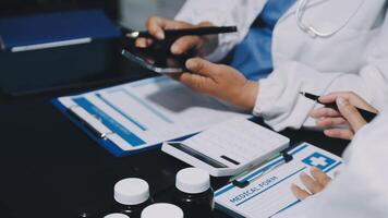 Two doctors are working on a computer and tablet video