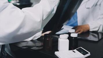 Two doctors are working on a computer and a tablet video