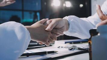 Two doctors shaking hands over a table video
