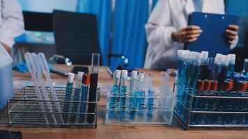A lab table with several test tubes and a clipboard video
