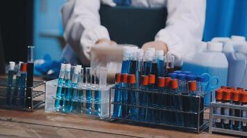 en person i en labb täcka är arbetssätt på en tabell med flera testa rör video