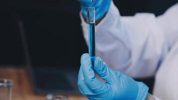 A person in a lab coat holding a test tube video