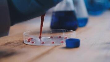 A person in a lab coat pouring liquid into a test tube video