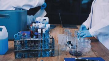 Two people in lab coats working on a table video