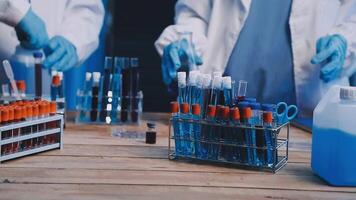Two people in lab coats are working on a table video
