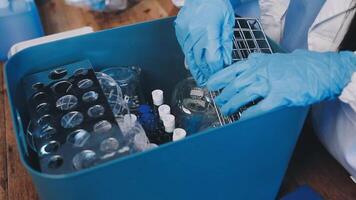 A person in a lab coat is holding a container with some bottles video