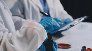Two people in lab coats and gloves are working on a project video