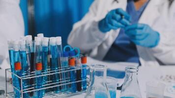 A person in a lab coat is working on a test tube video